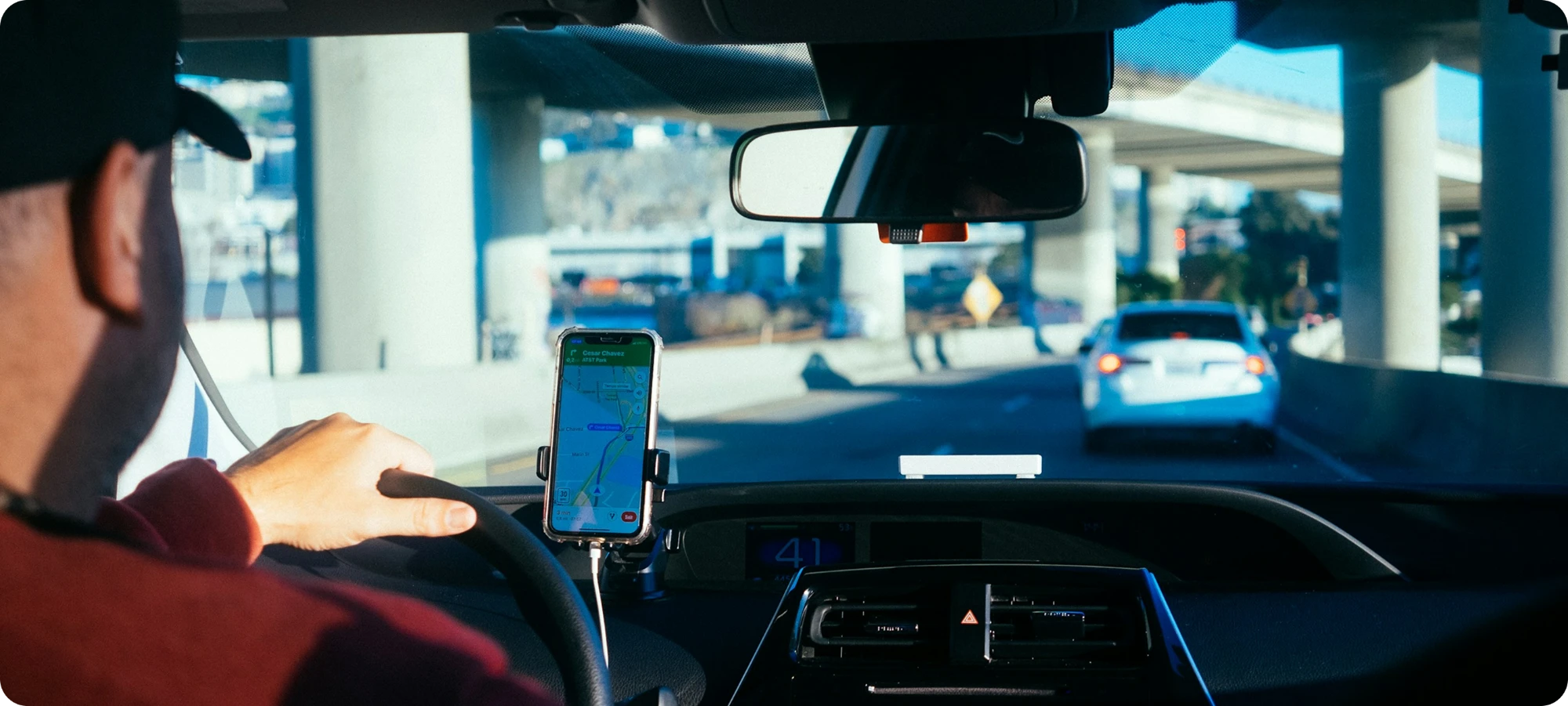 A driver following directions on a phone mounted in the car