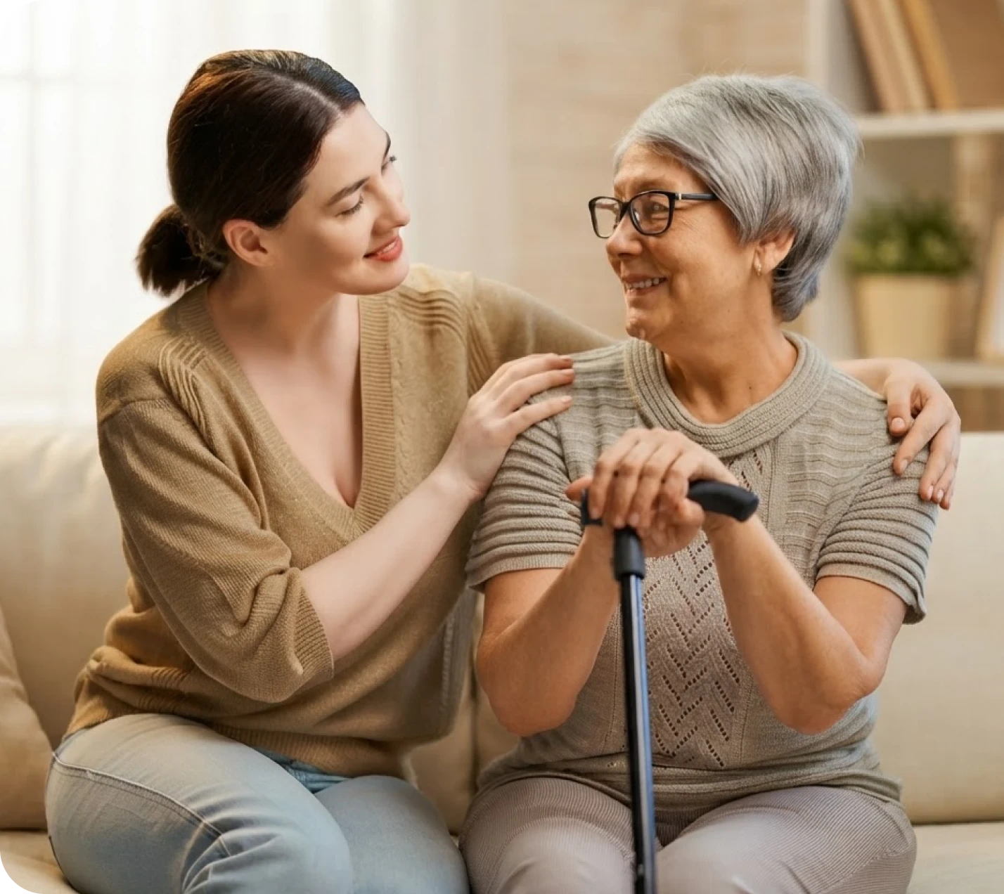 An older woman holding a cane, smiling with her caregiver